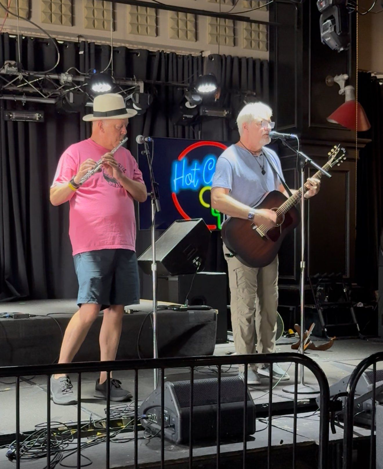Frank Oelschlager on acoustic guitar and vocals with a flute player on stage